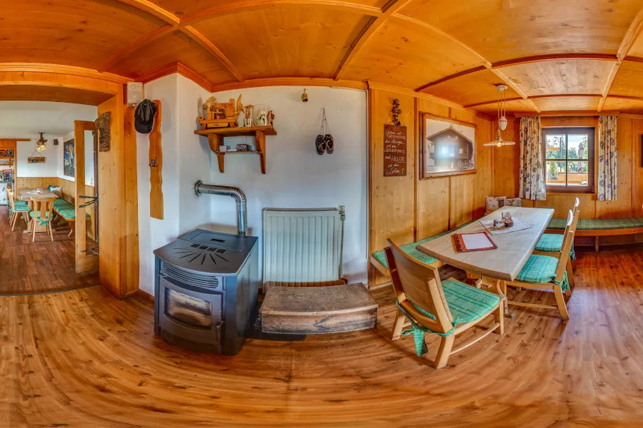 Die urige Stube der Tennalm mit Kachelofen und Holzbänken