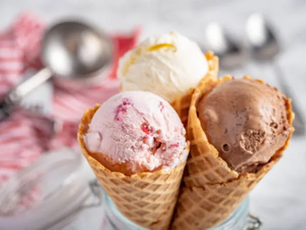 Drei Eiskugeln in Waffeltüten: Erdbeere, Schokolade und Vanille